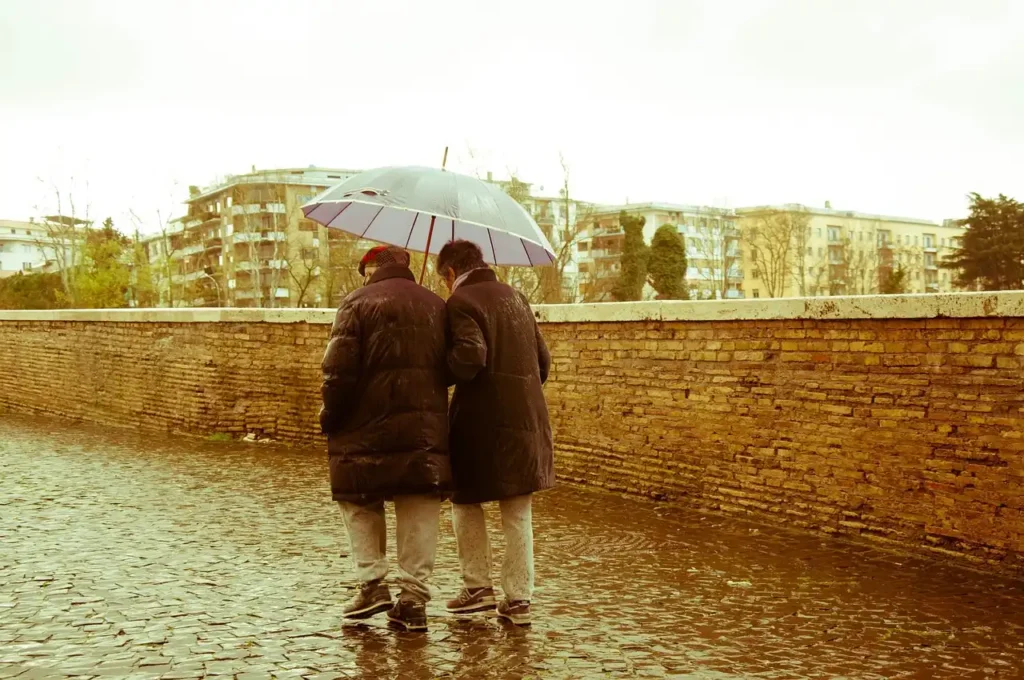 old couple walking in rain